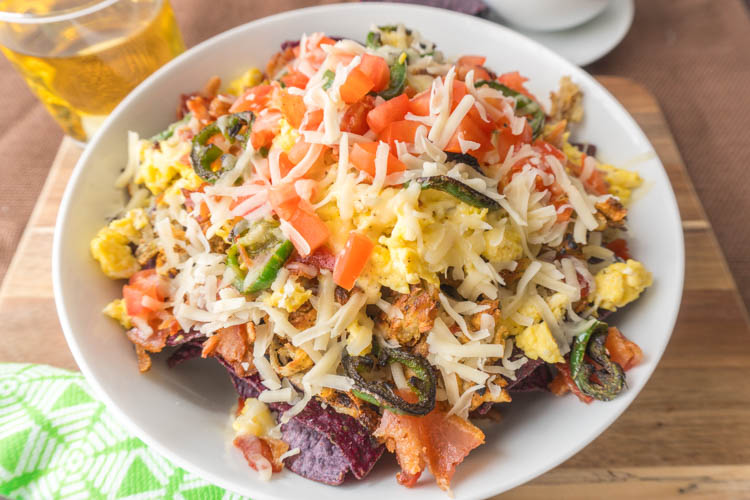  Easy breakfast nacho recipe with eggs, potatoes, jalepenos, bacon, cheese and tortilla chips! 