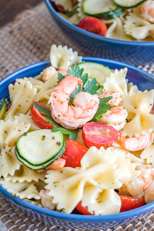 cold shrimp pasta salad has all the good stuff - bowtie pasta, grape tomatoes, zucchini, and shrimp all tossed in a yummy pesto vinaigrette - no diets allowed
